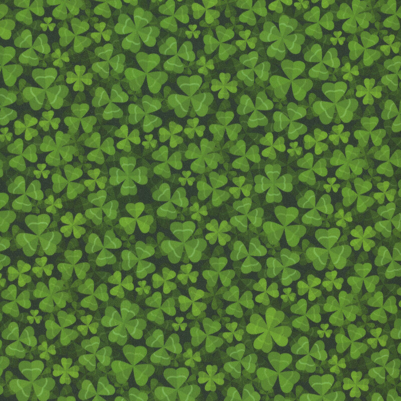 Fabric packed with shamrocks and four-leaf clovers against a dark green background