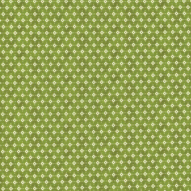 This fabric features clusters of cream white clover motifs in rows on a green mottled background.