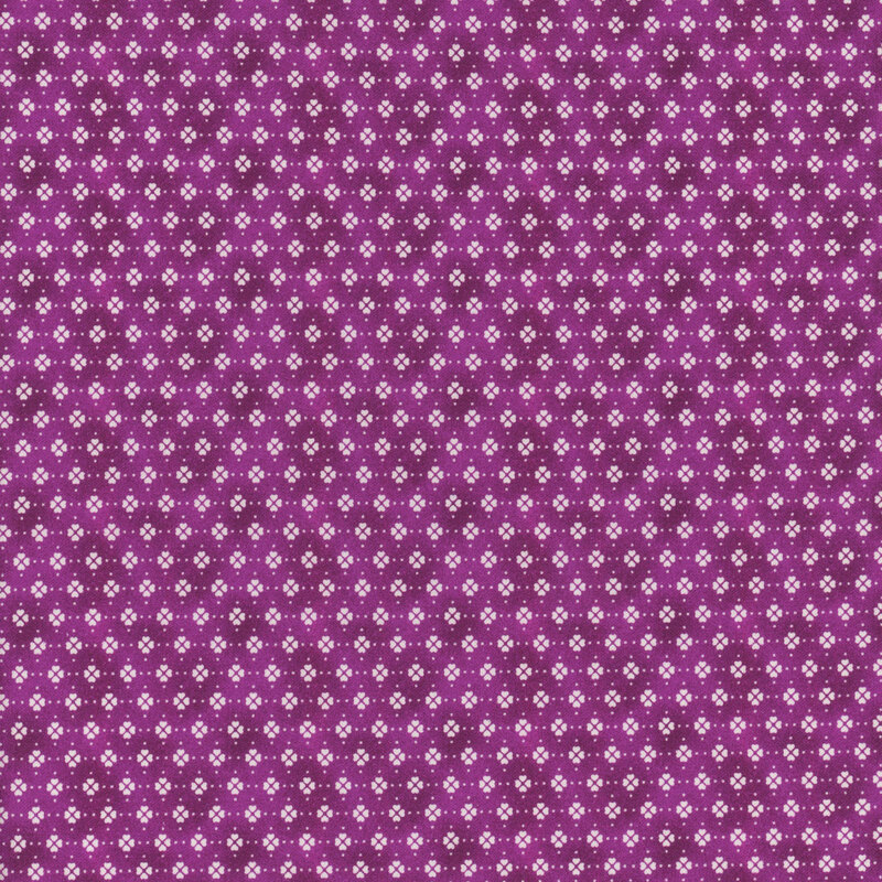 Fabric with clusters of cream white clover motifs in rows on a dark purple mottled background.