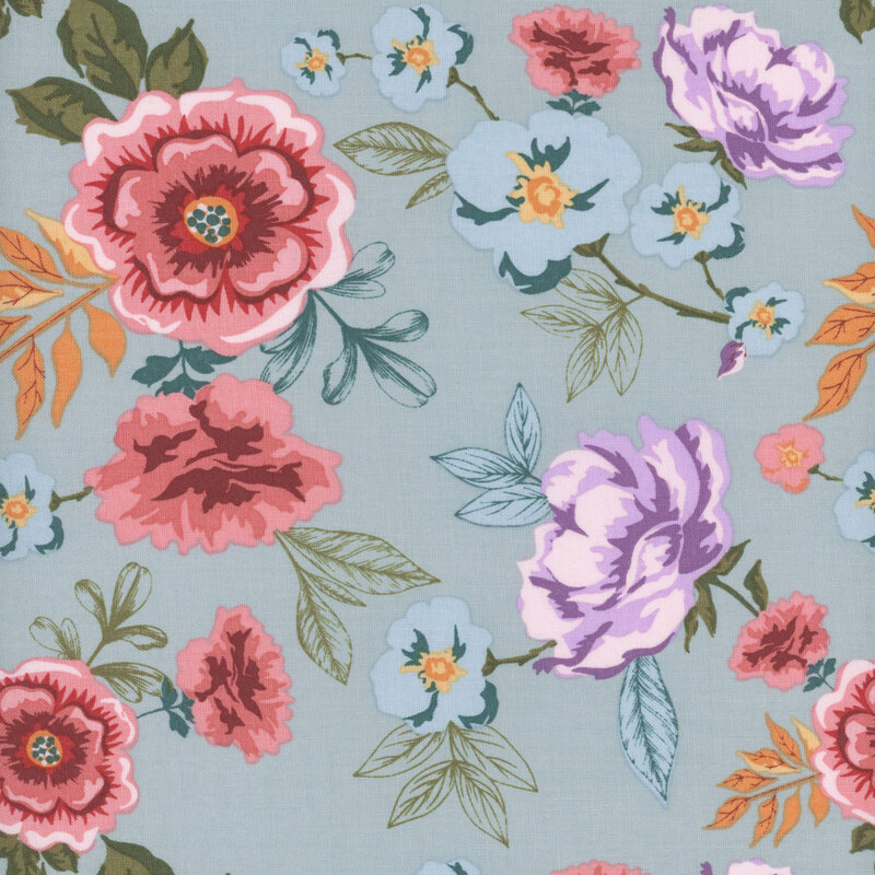 fabric featuring large rosy pink flowers, blue and purple blossoms and colorful green, teal and yellow leaves on a soft, delicate blue background.