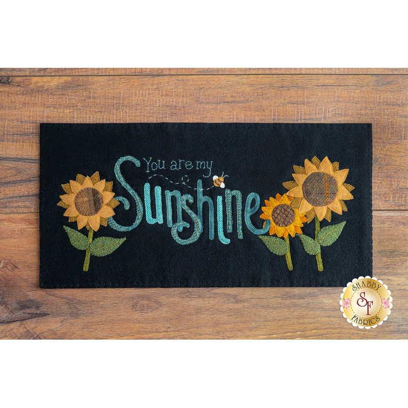 black rectangular table mat on a brown wooden countertop with the words 