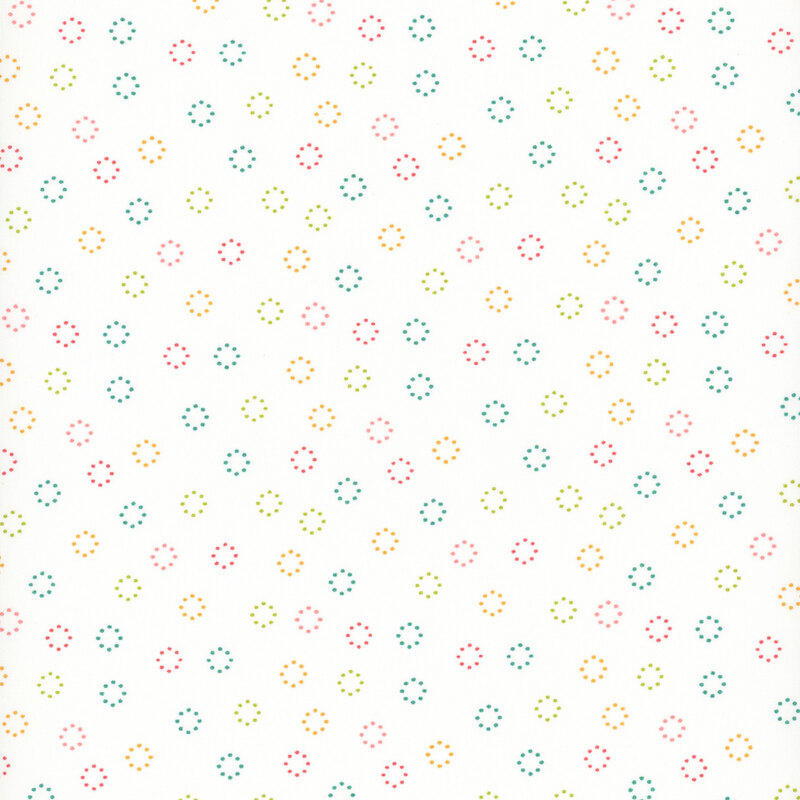 fabric featuring multicolor dotted circles tossed on a solid cream background.