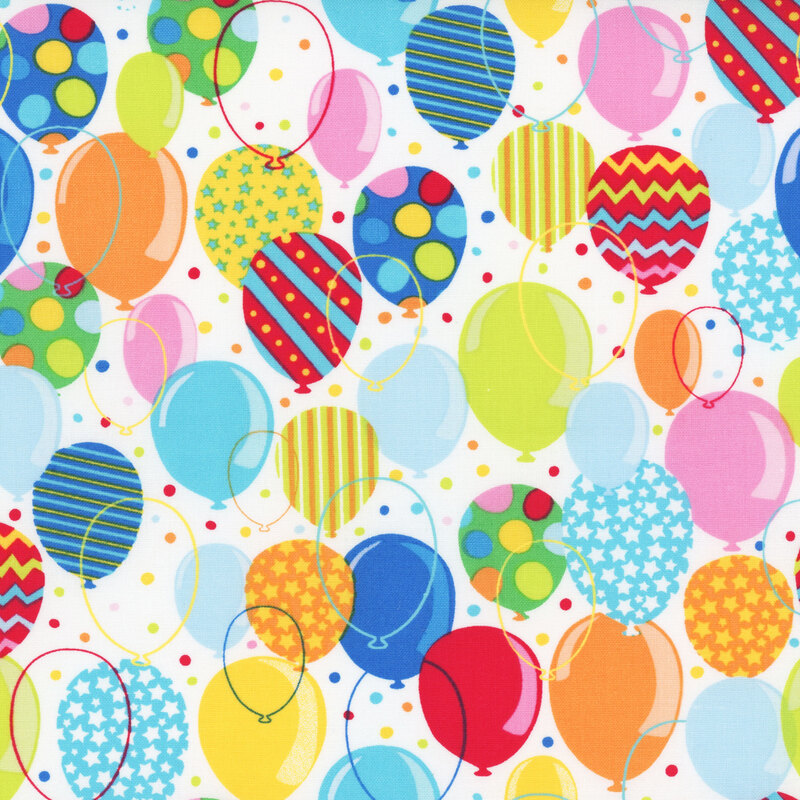 multicolored fabric featuring a white background with overlapping brightly colored confetti dots and balloons