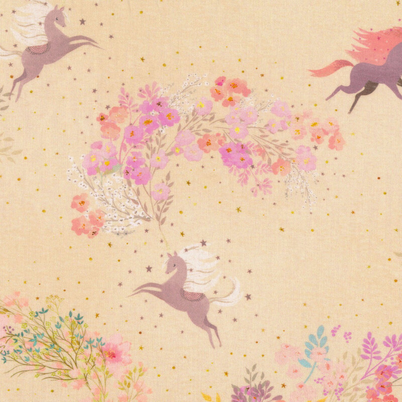 soft tan fabric featuring various unicorns with a trail of warm colored flowers from the horn with scattered stars