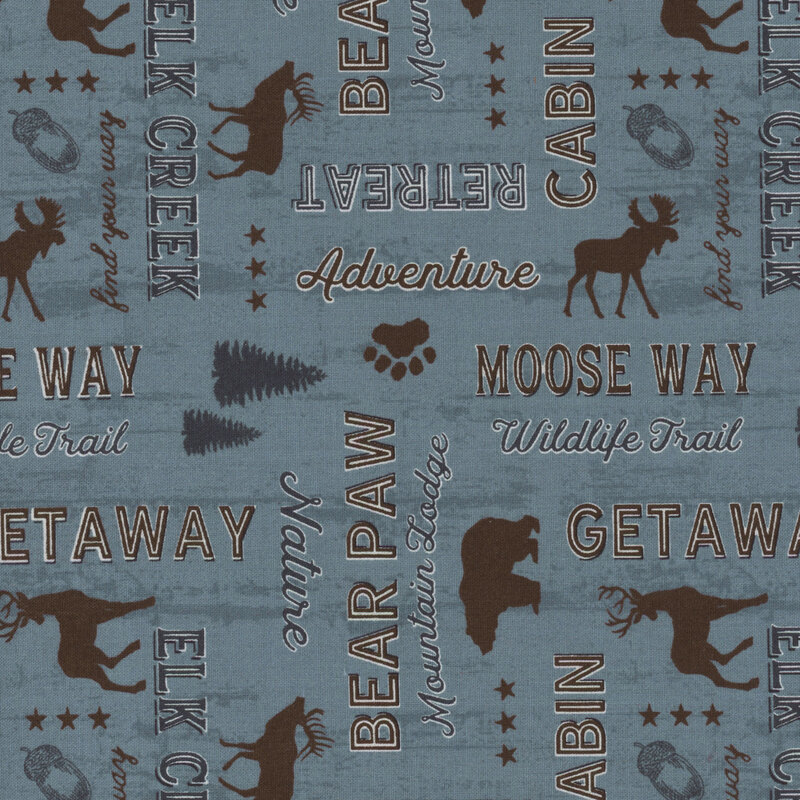 blue fabric features an array of adventure and nature sayings in dark brown and dark blue, interspersed with woodland creatures, such as bears, elk, and moose, along with trees, acorns, stars, and bear paw prints