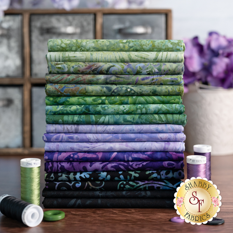 Styled photography of green, purple and black batik fabrics within the mystic vineyard collection FQ set