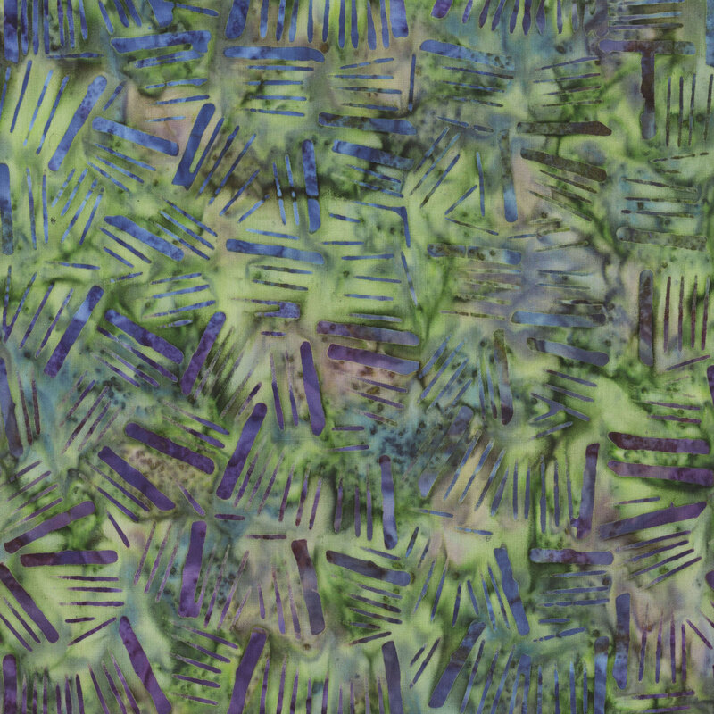green batik fabric featuring tonal mottling and mottled dashes across the fabric in blue and purple