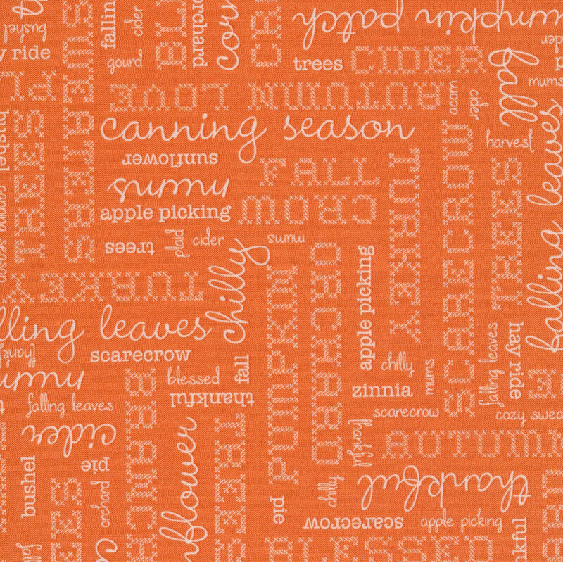 orange fabric featuring cream words in different fonts pertaining to autumn