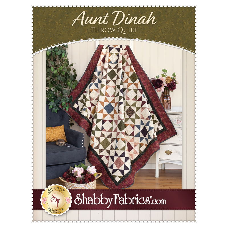 The front cover of the Aunt Dinah Throw Quilt pattern showing a finished quilt draped in front of a white paneled wall with furniture and a houseplant