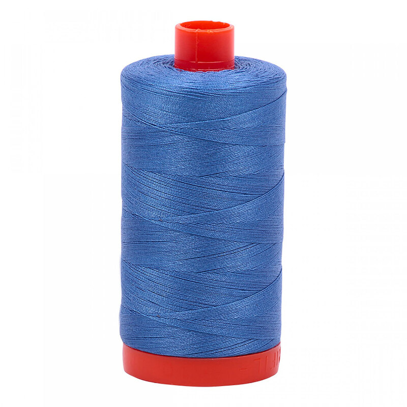 A spool of Aurifil 1128 - light blue violet thread on a white background