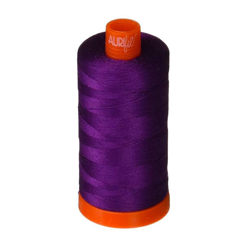 A spool of Aurifil 2545 - medium purple thread on a white background