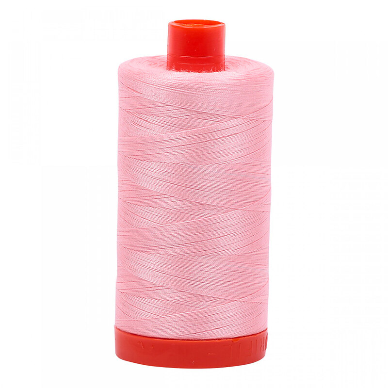 A spool of Aurifil 2415 - Blush thread on a white background