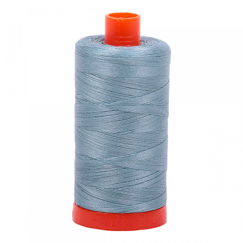 A spool of Aurifil 5008 - Sugar Paper thread on a white background