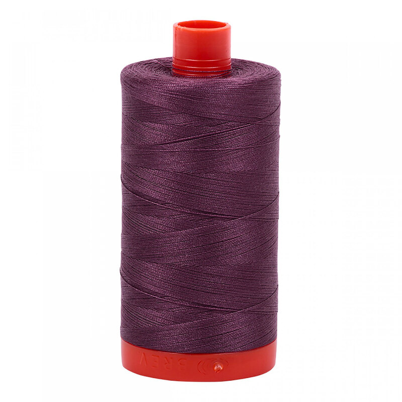 A spool of Aurifil 2568 - Mulberry thread on a white background
