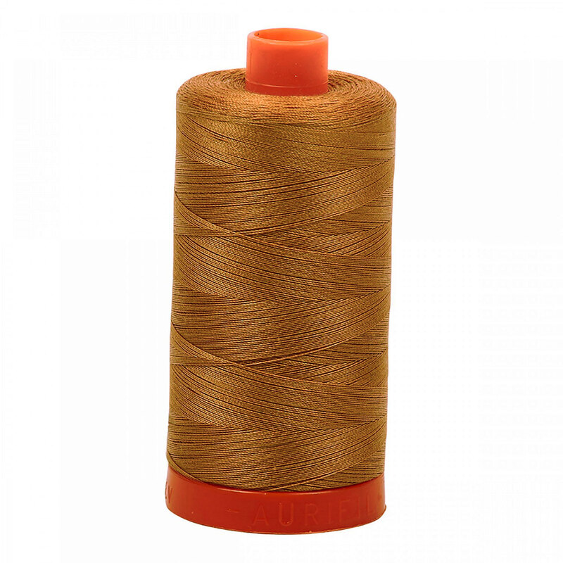 A spool of Aurifil 2335 - Light Cinnamon thread on a white background