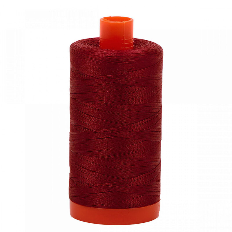 A spool of Aurifil 2460 - Dark Carmine Red thread on a white background