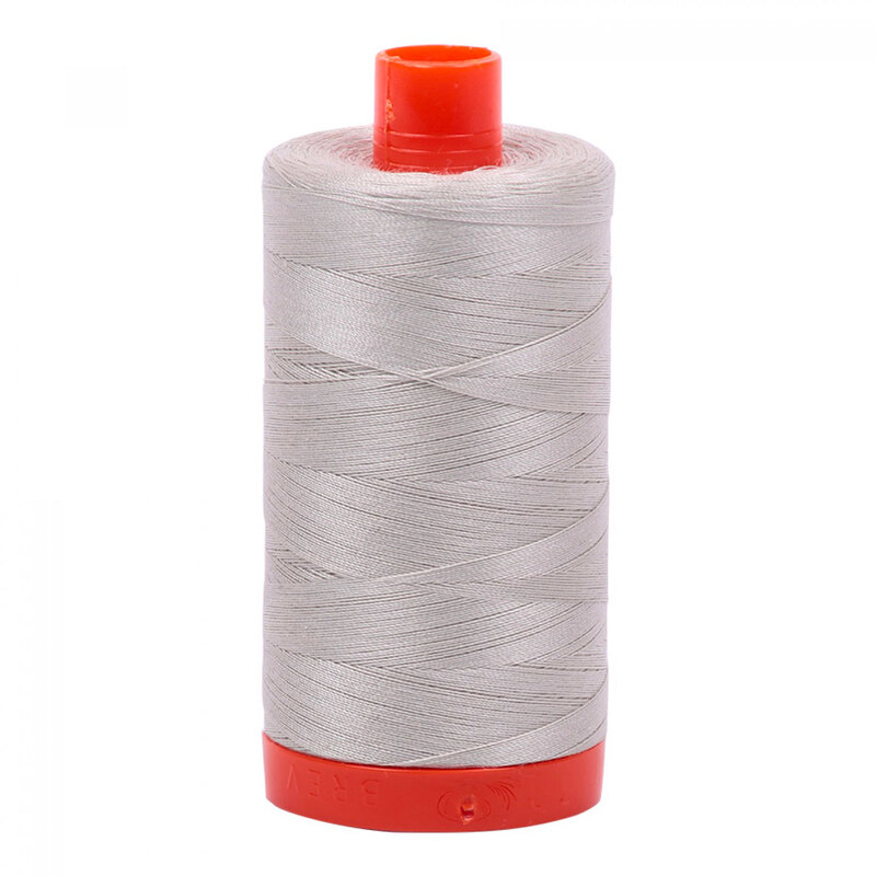 A spool of Aurifil 6724 - Moonshine thread on a white background