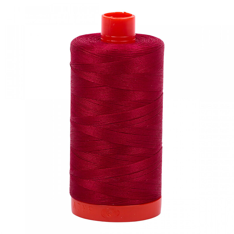 A spool of Aurifil 2260 - Red Wine thread on a white background