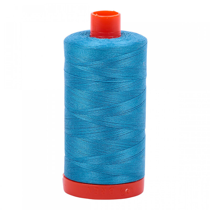 A spool of Aurifil 1320 - Bright Teal thread on a white background