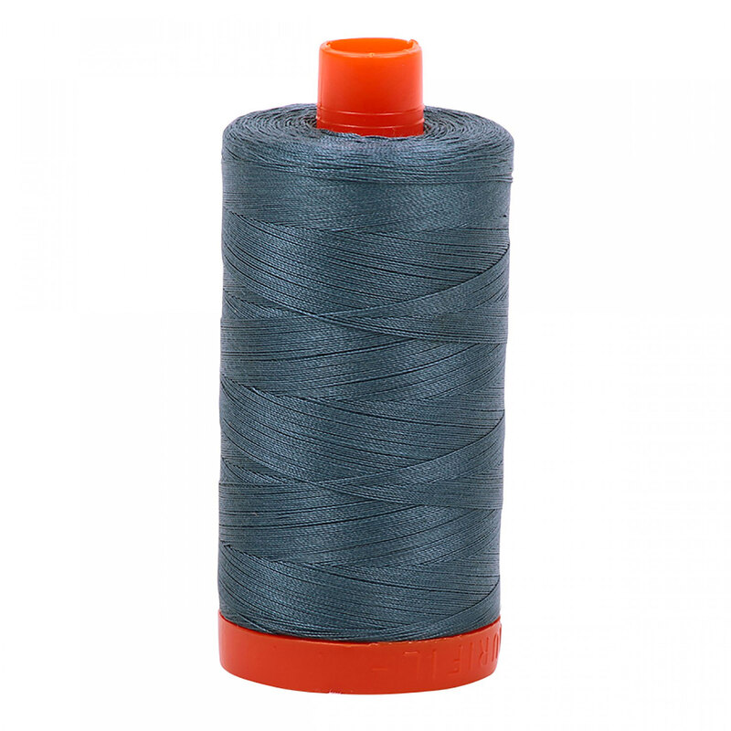 A spool of Aurifil 1310 - Medium Blue Grey thread on a white background