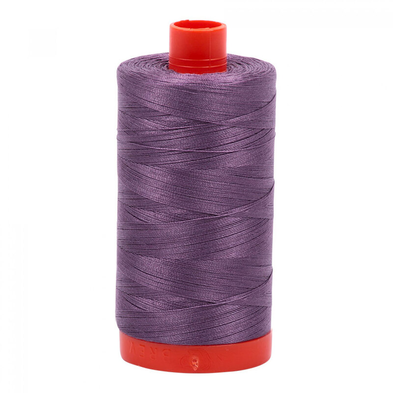 A spool of Aurifil 6735 - Plumtastic thread on a white background