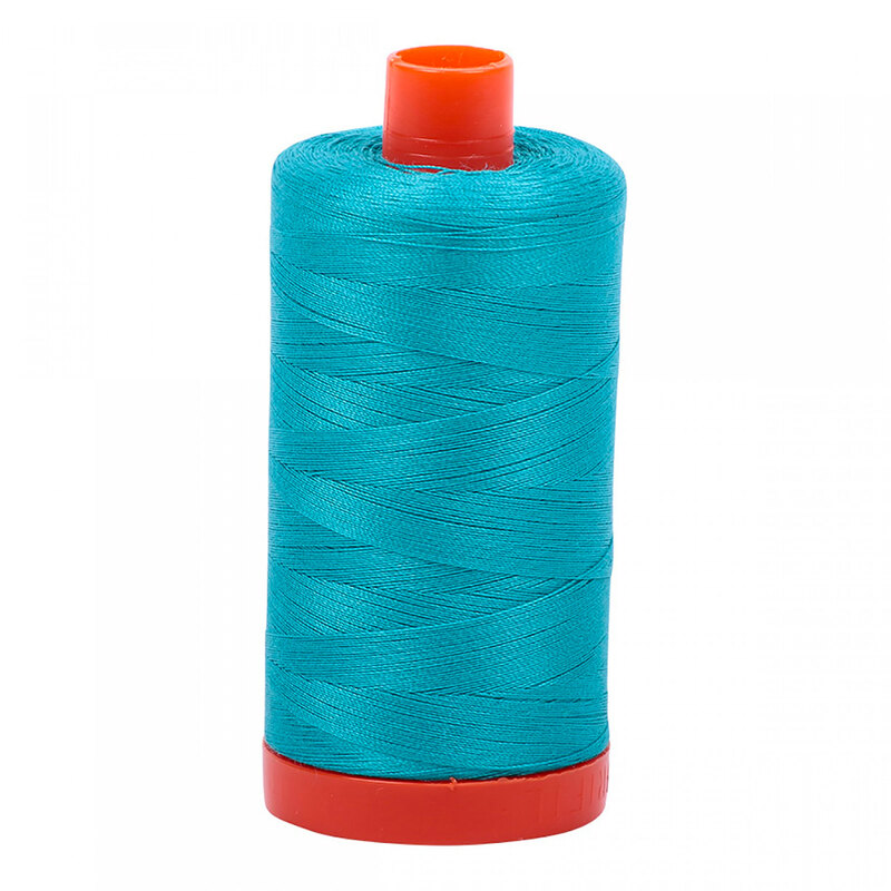 A spool of Aurifil 2810 -Turquoise thread on a white background