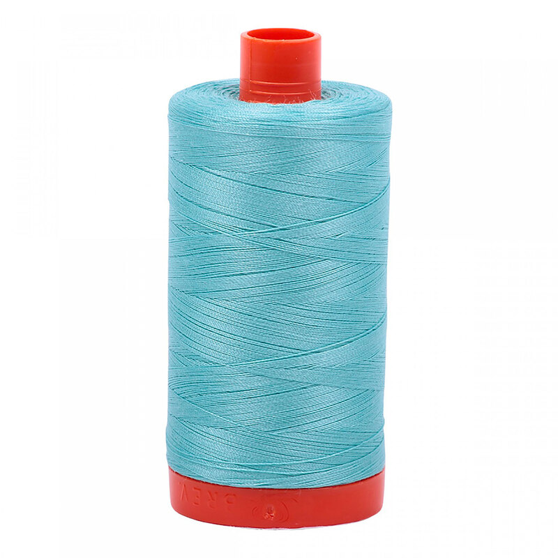 A spool of Aurifil 5006 -Light Turquoise thread on a white background