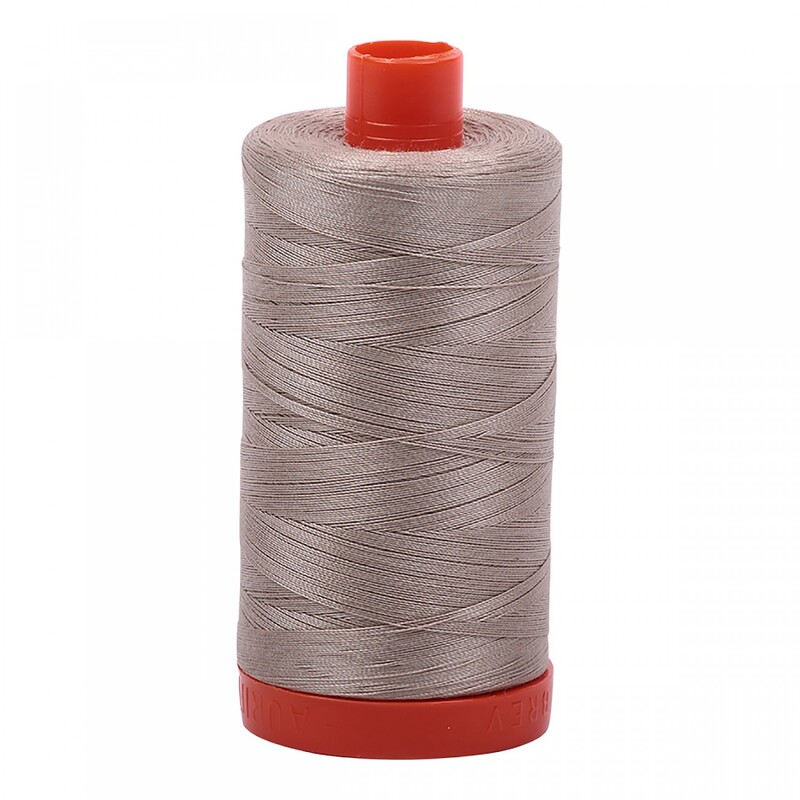 A spool of Aurifil 5011 -Rope Beige thread on a white background