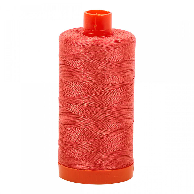 A spool of Aurifil 5002 - Medium Red thread on a white background