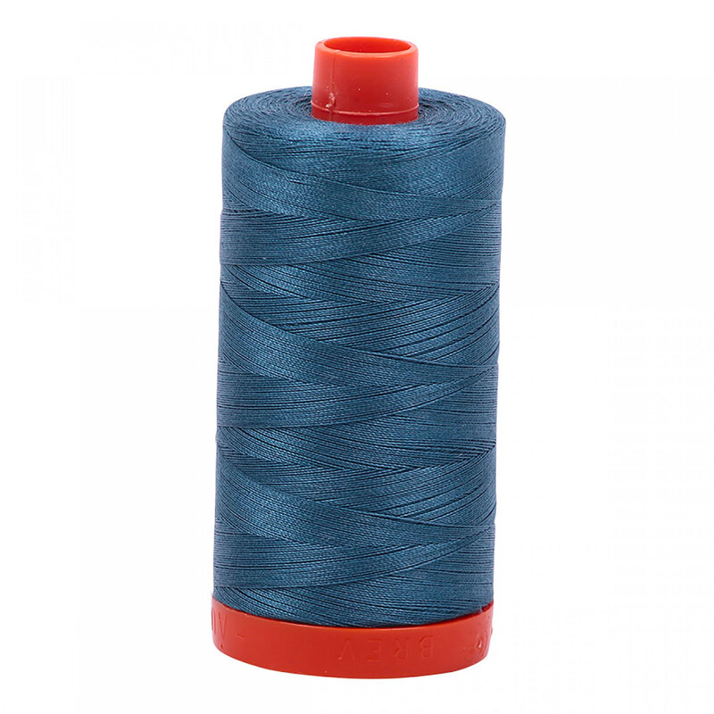 A spool of Aurifil 4644 - Smoke Blue thread on a white background