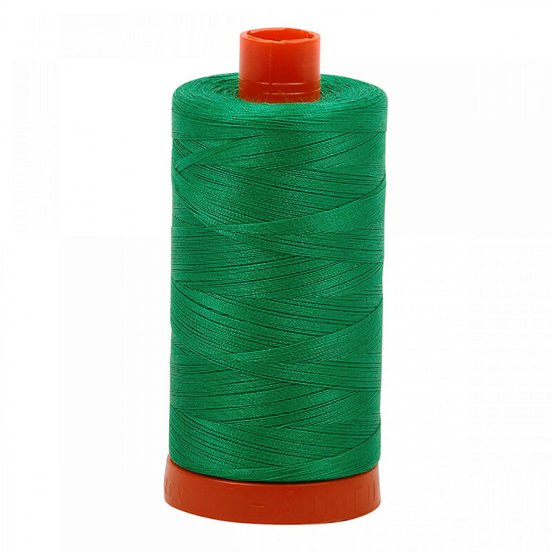 A spool of Aurifil 2865 - Emerald thread on a white background