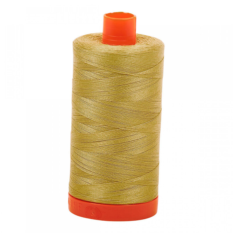 A spool of Aurifil 2915 - Very Light Brass thread on a white background