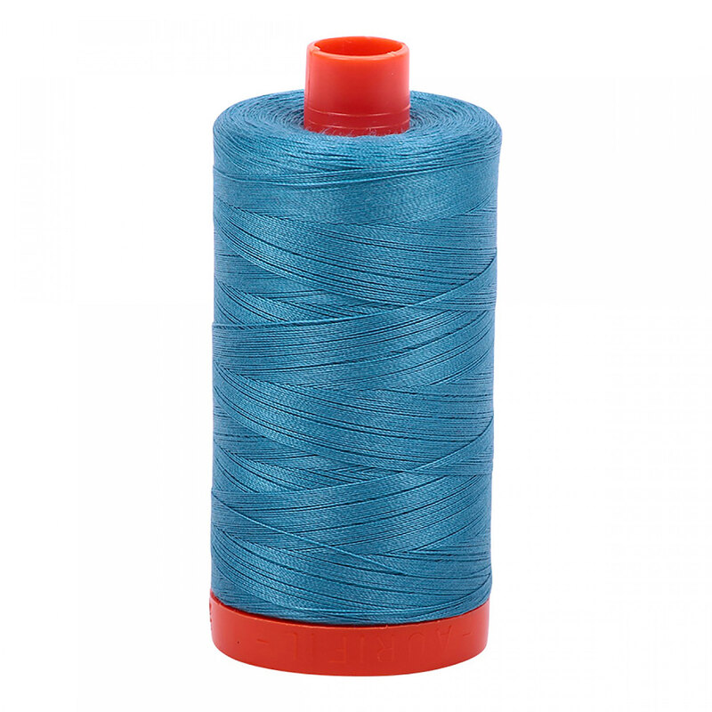 A spool of Aurifil 2815 - Teal thread on a white background