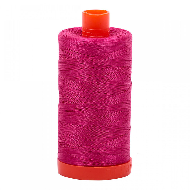 A spool of Aurifil 1100 - Red Plum thread on a white background