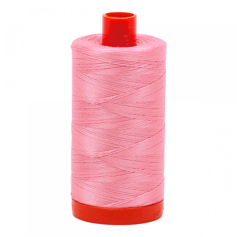 A spool of Aurifil 2425 -Bright Pink thread on a white background