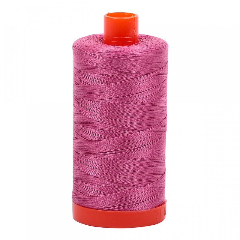 A spool of Aurifil 2452 -Dusty Rose thread on a white background