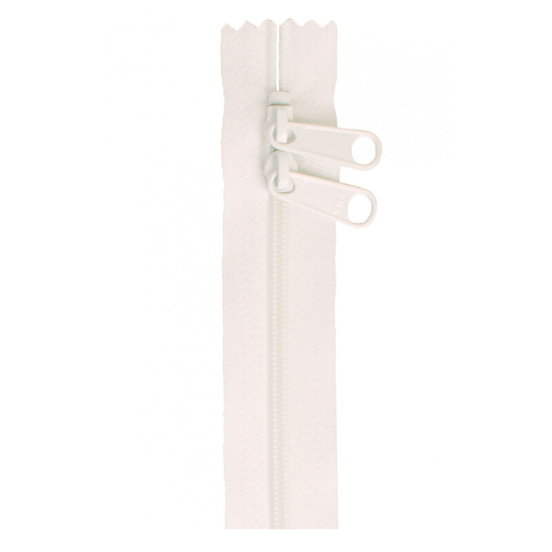Photo of a white zipper with two pull tabs isolated on a white background