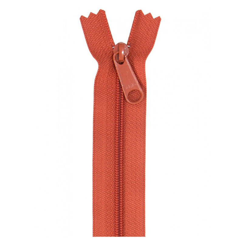 Photo of a burnt orange zipper isolated on a white background
