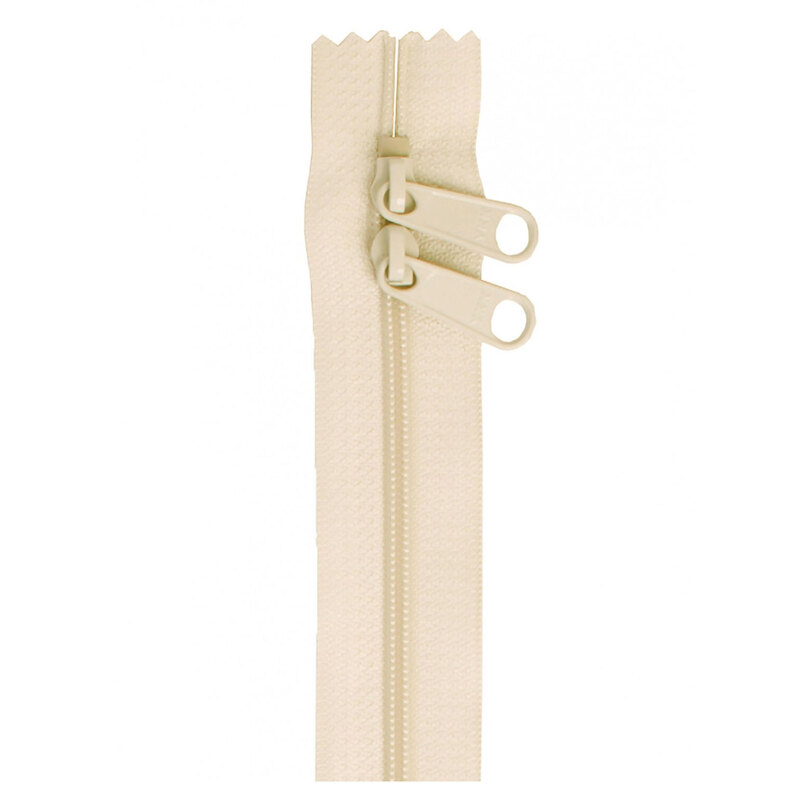 Photo of an off white zipper with two pull tabs isolated on a white background