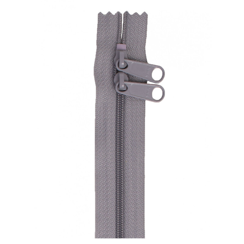 Photo of a gray zipper with two pull tabs isolated on a white background