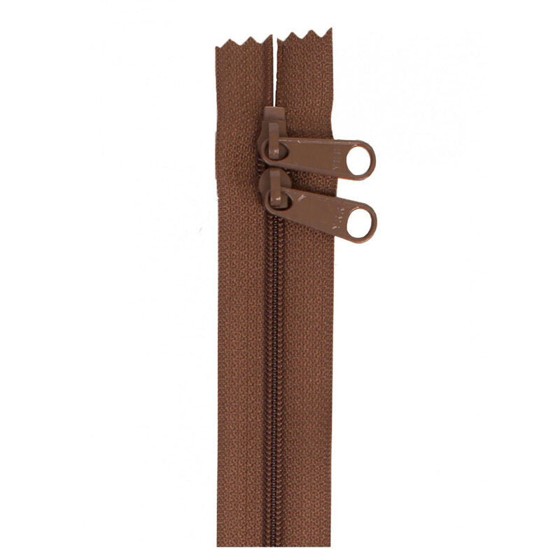 Photo of a brown zipper with two pull tabs isolated on a white background