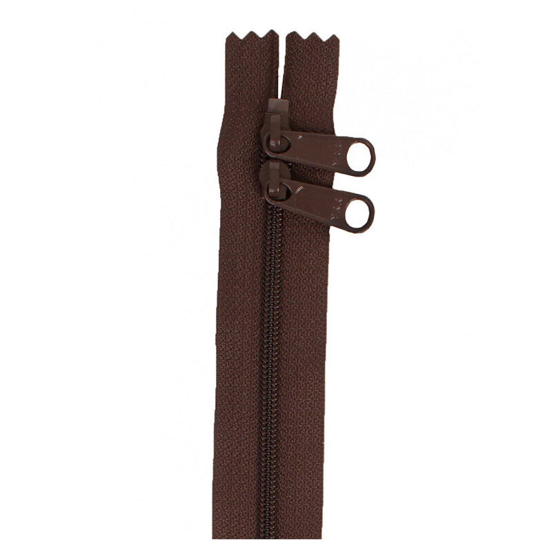Photo of a brown zipper with two pull tabs isolated on a white background