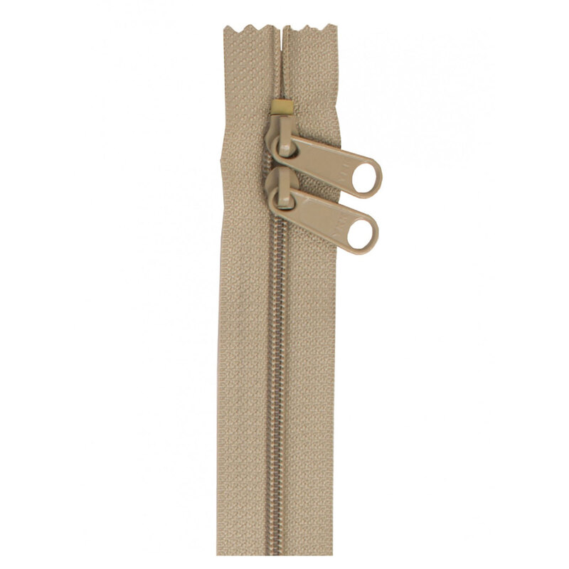 Photo of a beige-green zipper with two pull tabs isolated on a white background