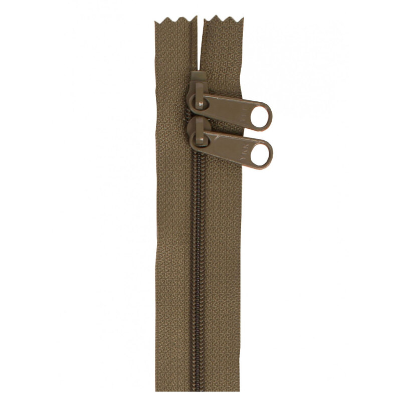 Photo of a dark green-brown zipper with two pull tabs isolated on a white background