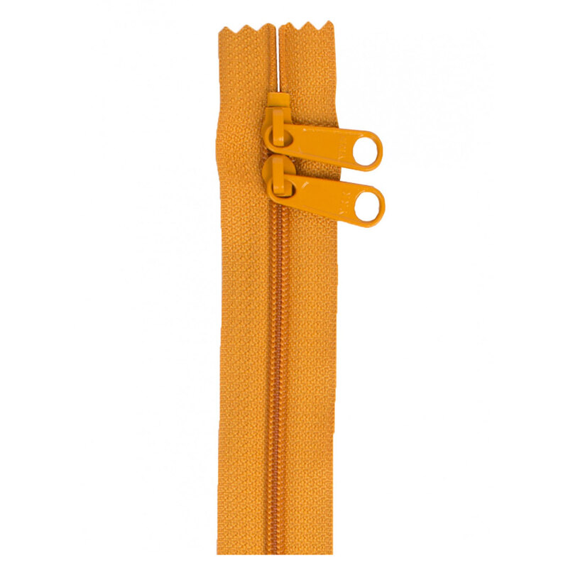 Photo of a mustard zipper with two pull tabs isolated on a white background