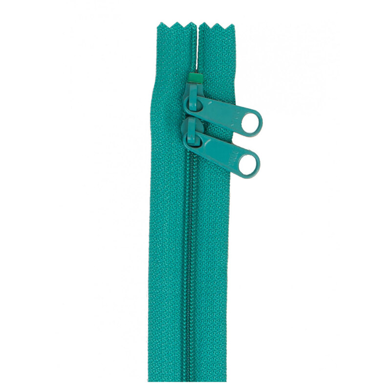 Photo of a teal zipper with two pull tabs isolated on a white background
