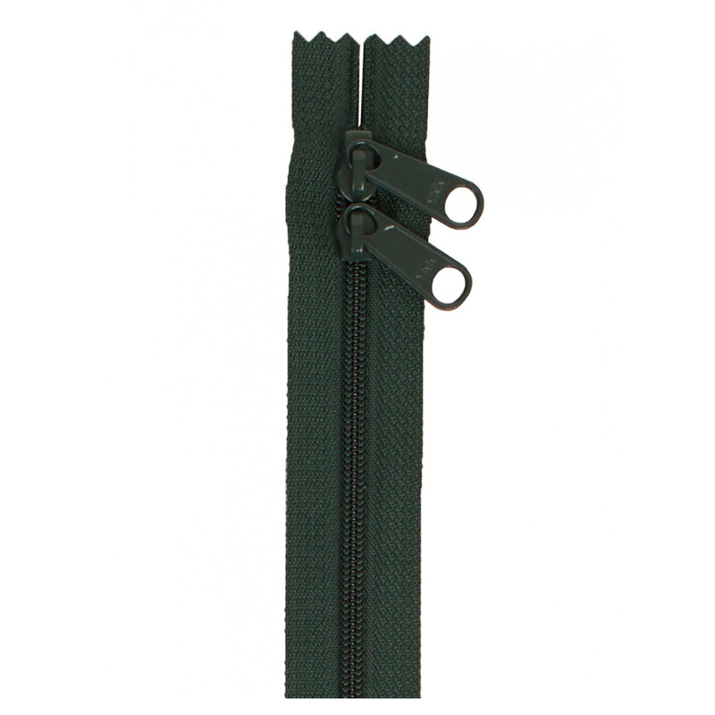 Photo of a dark green zipper with two pull tabs isolated on a white background