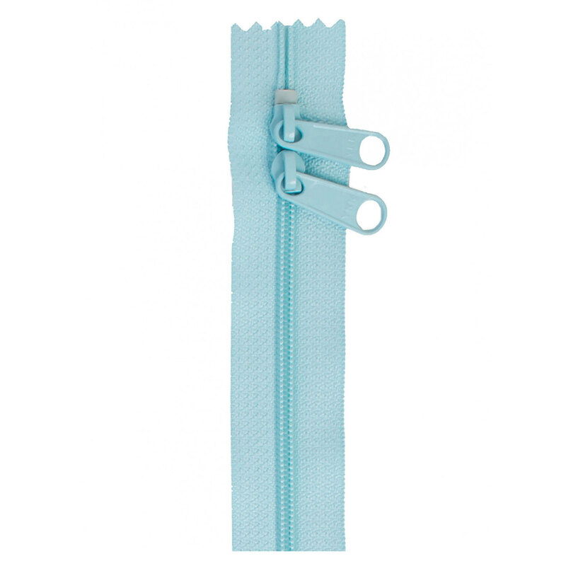 Photo of a light blue zipper with two pull tabs isolated on a white background