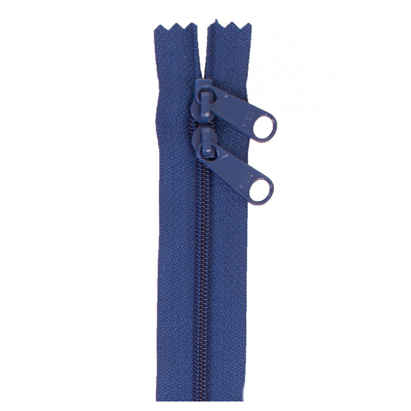 Photo of a dark blue zipper with two pull tabs isolated on a white background
