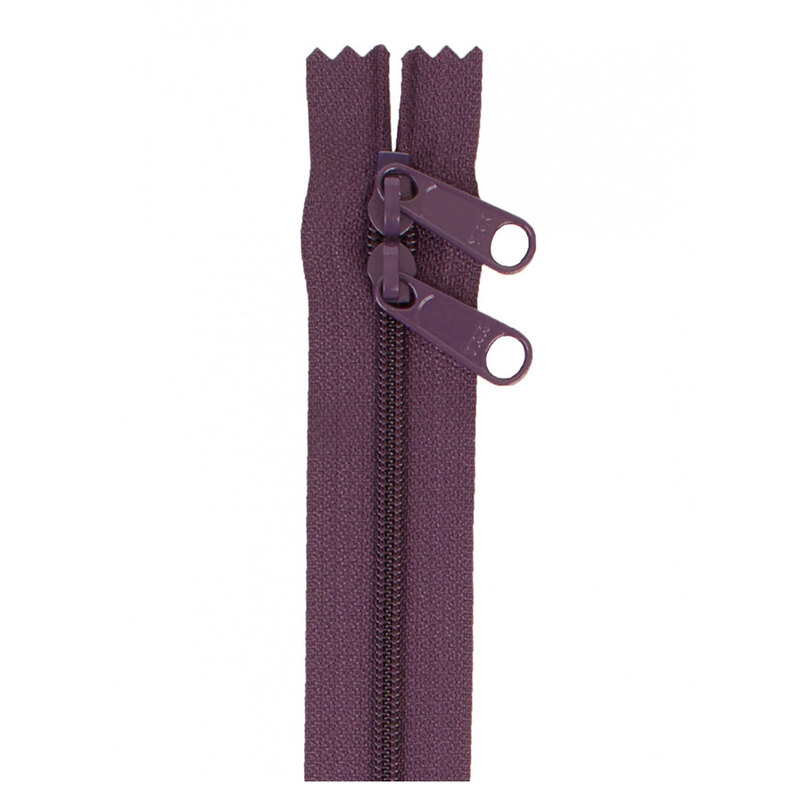 Photo of a dark purple zipper with two pull tabs isolated on a white background